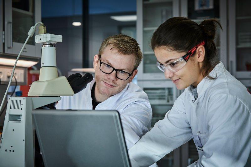 laboratorie, to personer i hvide kitler  