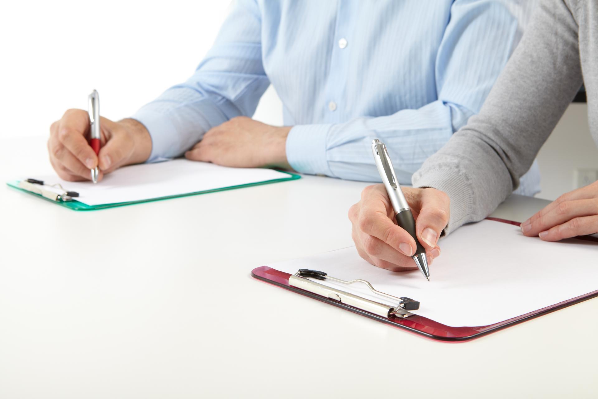 to personer skriver på et clipboard